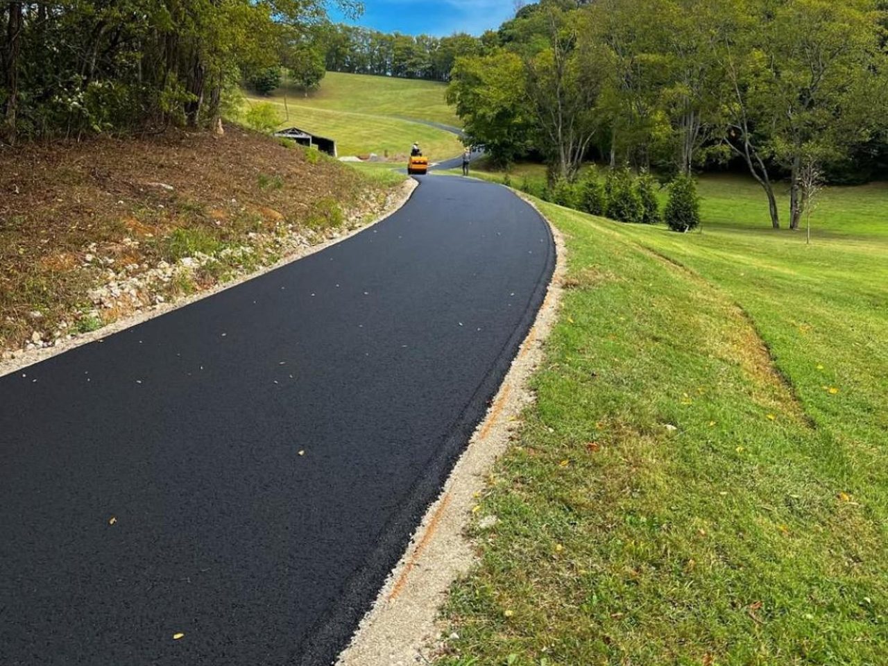 A freshly laid tarmac driveway winding through the countryside